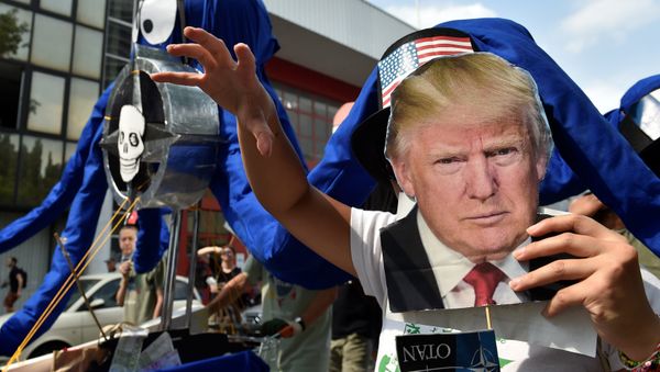 A participant holds the portrait of U.S. President Donald Trump as protesters take part in a march against the NATO leaders summit, in Brussels, Belgium July 7, 2018. A participant holds the portrait of U.S. President Donald Trump as protesters take part in a march against the NATO leaders summit, in Brussels, Belgium July 7, 2018. - Sputnik International