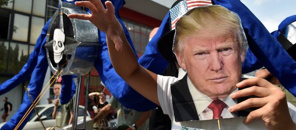A participant holds the portrait of U.S. President Donald Trump as protesters take part in a march against the NATO leaders summit, in Brussels, Belgium July 7, 2018. A participant holds the portrait of U.S. President Donald Trump as protesters take part in a march against the NATO leaders summit, in Brussels, Belgium July 7, 2018. - Sputnik International