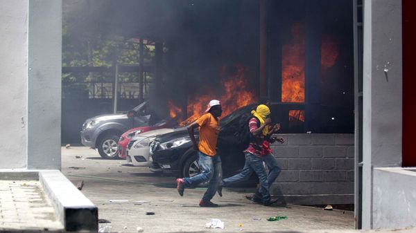 People run away after cars were set on fire at a Nissan dealership during protests over a fuel price increase in Port-au-Prince, Haiti, on Saturday, July 7, 2018 - Sputnik International