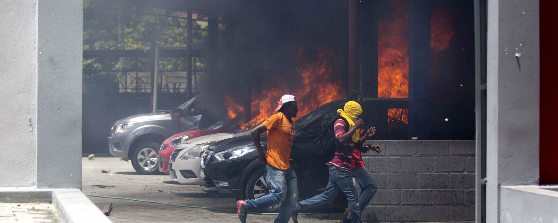 People run away after cars were set on fire at a Nissan dealership during protests over a fuel price increase in Port-au-Prince, Haiti, on Saturday, July 7, 2018 People run away after cars were set on fire at a Nissan dealership during protests over a fuel price increase in Port-au-Prince, Haiti, on Saturday, July 7, 2018 - Sputnik International, 1920, 08.10.2022