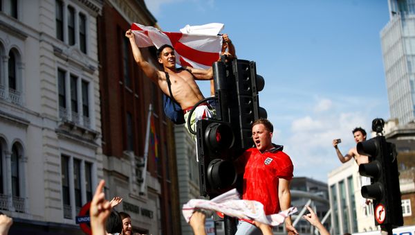 Soccer Football - World Cup - England fans watch Sweden vs England - London, Britain - July 7, 2018 England fans celebrate by climbing traffic lights after the match - Sputnik International