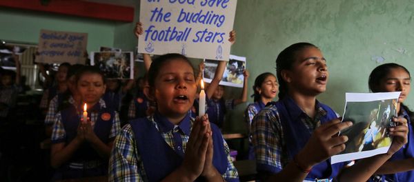 Schoolchildren pray for the schoolboys who are trapped inside a flooded cave in Thailand's northern province of Chiang Rai, at a school in Ahmedabad, India, July 9, 2018. - Sputnik International