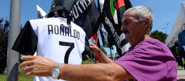 A vendor adjusts a Juventus' jerseys with the name of Cristiano Ronaldo exhibited in his shop in Turin, Italy July 7, 2018 - Sputnik International