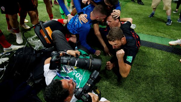 Soccer Football - World Cup - Semi Final - Croatia v England - Luzhniki Stadium, Moscow, Russia - July 11, 2018 Croatia players celebrate next to an AFP photographer Yuri Cortez after Mario Mandzukic scores their second goal Soccer Football - World Cup - Semi Final - Croatia v England - Luzhniki Stadium, Moscow, Russia - July 11, 2018 Croatia players celebrate next to an AFP photographer Yuri Cortez after Mario Mandzukic scores their second goal - Sputnik International
