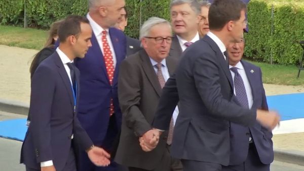 In this Wednesday, July 11, 2018 grab taken from video, European Union leader Jean-Claude Juncker is helped by Netherlands Prime Minister Mark Rutte at Brussels Parc Cinquantenaire, in Brussels, Belgium. - Sputnik International