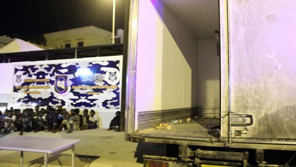 (File) Men from African countries sit in Tripoli on June 4, 2017 next to a truck which was used to carry illegal migrants in the area of the coastal town of Guarabouli, 60 kilometres (36 miles) east of the Libyan capital - Sputnik International