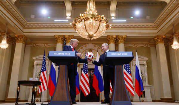 U.S. President Donald Trump receives a football from Russia's President Vladimir Putin during their joint news conference after a meeting in Helsinki, Finland, July 16, 2018 - Sputnik International