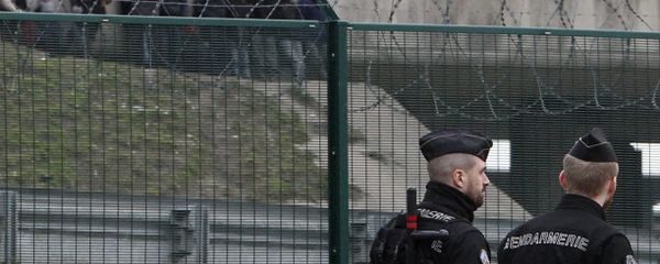 Migrants, background, watch French gendarmes patrolling on the road leading to the port in Calais, northern France, Friday Feb.2, 2018. Police reinforcements are arriving in the French port city of Calais after clashes among migrants left 22 people injured, as the interior minister warned of a worrying spike in violence - Sputnik International