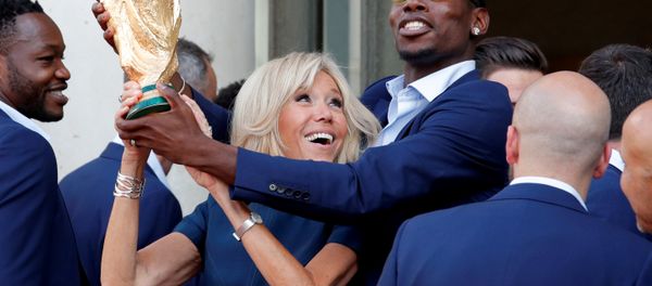 Brigitte Macron, the wife of French President Emmanuel Macron (not pictured), and player Paul Pogba hold the trophy before a reception to honour the France soccer team after their victory in the 2018 Russia Soccer World Cup, at the Elysee Palace in Paris, France, July 16, 2018 - Sputnik International