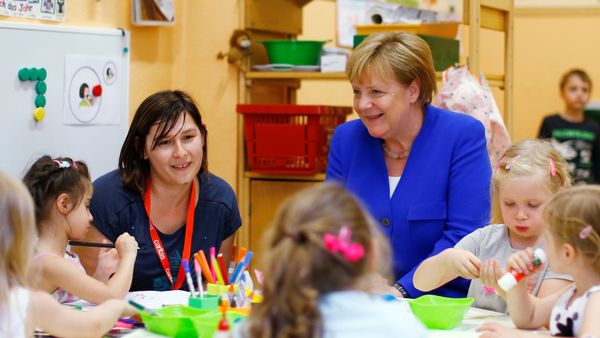 Chancellor Angela Merkel sits with kids at the Caritas Association kindergarten in Cologne, Germany, July 18, 2018 - Sputnik International