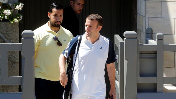 French President Emmanuel Macron, flanked by Alexandre Benalla, French presidential aide, carries a racquet as he leaves his home to play tennis in Le Touquet, France, June 17, 2017. Picture taken June 17, 2017 - Sputnik International