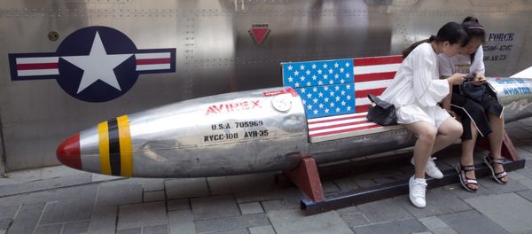 Chinese women look at phone near a rocket shaped bench with an American flag used as a marketing gimmick for a U.S. apparel shop in Beijing, China, Friday, July 6, 2018 Chinese women look at phone near a rocket shaped bench with an American flag used as a marketing gimmick for a U.S. apparel shop in Beijing, China, Friday, July 6, 2018 - Sputnik International