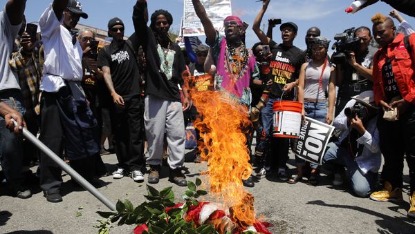 People chant slogans as they burn a U.S. flag outside the Los Angeles office of U.S. Rep. Maxine Waters, Thursday, July 19, 2018, in Los Angeles. - Sputnik International