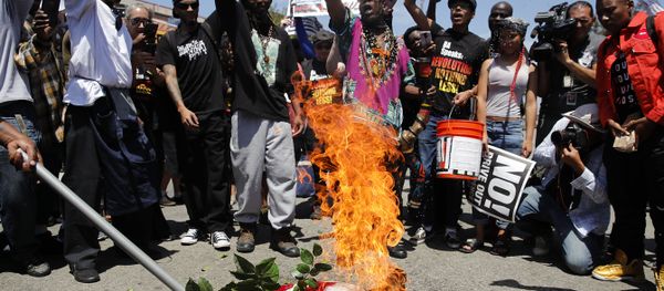 People chant slogans as they burn a U.S. flag outside the Los Angeles office of U.S. Rep. Maxine Waters, Thursday, July 19, 2018, in Los Angeles. People chant slogans as they burn a U.S. flag outside the Los Angeles office of U.S. Rep. Maxine Waters, Thursday, July 19, 2018, in Los Angeles. - Sputnik International