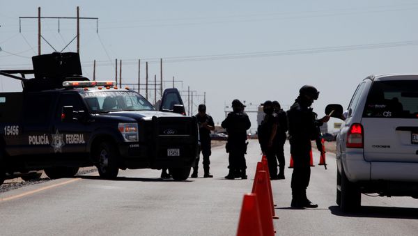 A federal police officer (R) inspect a vehicle at a security checkpoint near a prison in Ciudad Juarez where Mexican drug boss Joaquin Chapo Guzman has been moved from his jail in central Mexico May 7, 2016 - Sputnik International