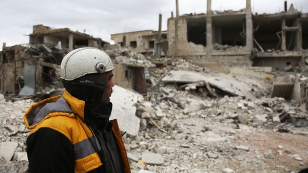 Forty-five-year-old Samir Salim (L) who along with his three brothers are members of the White Helmets rescue forces looks out at destroyed buildings in the town of Medeira in Syria's rebel-held Eastern Ghouta area on February 12 2018. Forty-five-year-old Samir Salim (L) who along with his three brothers are members of the White Helmets rescue forces looks out at destroyed buildings in the town of Medeira in Syria's rebel-held Eastern Ghouta area on February 12 2018. - Sputnik International