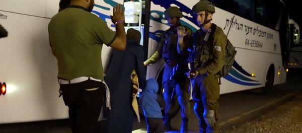 People walk past Israeli soldiers as they board a bus during the Syria Civil Defence, also known as the White Helmets, extraction from the Golan Heights, Israel in this still image taken from video, provided by the Israeli Army July 22, 2018 People walk past Israeli soldiers as they board a bus during the Syria Civil Defence, also known as the White Helmets, extraction from the Golan Heights, Israel in this still image taken from video, provided by the Israeli Army July 22, 2018 - Sputnik International
