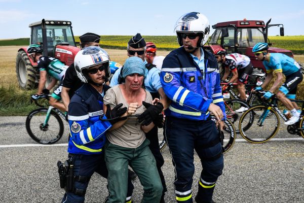 Gendarmes detain a protesting farmer as the pack rides behind during the 16th stage of the 105th edition of the Tour de France cycling race, between Carcassonne and Bagneres-de-Luchon, southwestern France, on July 24, 2018 - Sputnik International