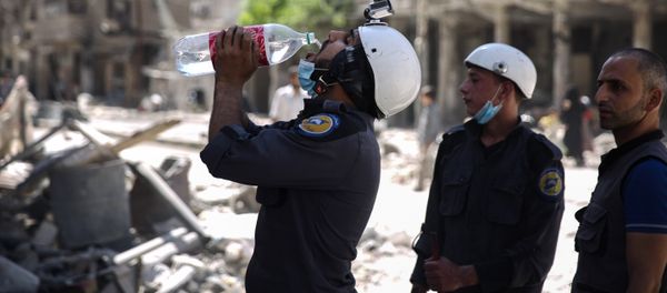 (File) Syrian civil defence volunteers, known as the White Helmets, take a break as they work at the site of a reported air strike in the rebel-held town of Douma, on the eastern outskirts of the capital Damascus, on October 5, 2016 (File) Syrian civil defence volunteers, known as the White Helmets, take a break as they work at the site of a reported air strike in the rebel-held town of Douma, on the eastern outskirts of the capital Damascus, on October 5, 2016 - Sputnik International