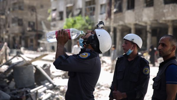 (File) Syrian civil defence volunteers, known as the White Helmets, take a break as they work at the site of a reported air strike in the rebel-held town of Douma, on the eastern outskirts of the capital Damascus, on October 5, 2016 (File) Syrian civil defence volunteers, known as the White Helmets, take a break as they work at the site of a reported air strike in the rebel-held town of Douma, on the eastern outskirts of the capital Damascus, on October 5, 2016 - Sputnik International