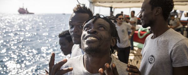 Migrants aboard the Open Arms aid boat, of Proactiva Open Arms Spanish NGO, react as the ship approaches the port of Barcelona, Spain, Wednesday, July 4, 2018. The aid boat sailed to Spain with 60 migrants rescued on Saturday in waters near Libya, after it was rejected by both Italy and Malta Migrants aboard the Open Arms aid boat, of Proactiva Open Arms Spanish NGO, react as the ship approaches the port of Barcelona, Spain, Wednesday, July 4, 2018. The aid boat sailed to Spain with 60 migrants rescued on Saturday in waters near Libya, after it was rejected by both Italy and Malta - Sputnik International