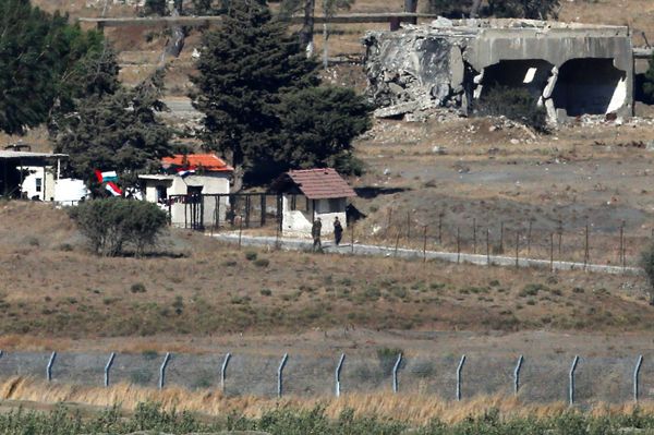Uniformed men walk near a building with Syrian and Ba'ath Party flags in Quneitra, on the Syrian side of the ceasefire line between Israel and Syria, as seen from the Israeli-occupied Golan Heights, July 26, 2018 Uniformed men walk near a building with Syrian and Ba'ath Party flags in Quneitra, on the Syrian side of the ceasefire line between Israel and Syria, as seen from the Israeli-occupied Golan Heights, July 26, 2018 - Sputnik International