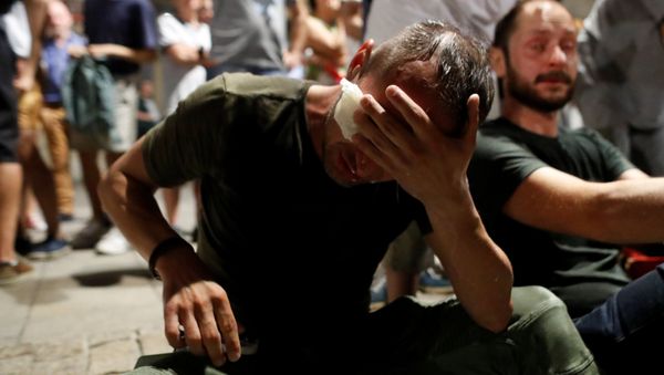 A man tends his eyes after clashes with police officers during the Chain of lights protest against judicial overhaul next to Presidential Palace in Warsaw, Poland July 26, 2018 A man tends his eyes after clashes with police officers during the Chain of lights protest against judicial overhaul next to Presidential Palace in Warsaw, Poland July 26, 2018 - Sputnik International