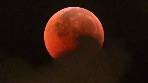A blood moon rises during a complete lunar eclipse, in Hong Kong, Saturday, July 28, 2018. Curiosity and awe have greeted a complete lunar eclipse, the longest one of this century and visible in much of the world. - Sputnik International