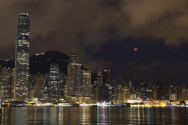 A full moon rises over the Victoria Harbour during a complete lunar eclipse, in Hong Kong, Saturday, July 28, 2018. Skywatchers around much of the world are looking forward to a complete lunar eclipse that will be the longest this century.  - Sputnik International