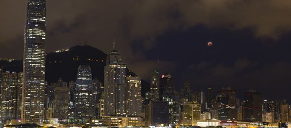 A full moon rises over the Victoria Harbour during a complete lunar eclipse, in Hong Kong, Saturday, July 28, 2018. Skywatchers around much of the world are looking forward to a complete lunar eclipse that will be the longest this century. - Sputnik International