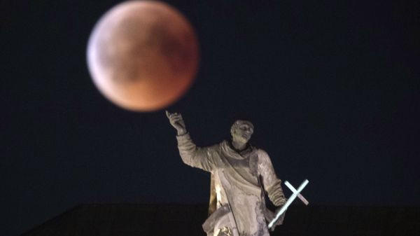 The moon turns red during a total lunar eclipse, as seen from Dresden, Germany, Friday, July 27, 2018. Skywatchers around much of the world are looking forward to a complete lunar eclipse that will be the longest this century.  - Sputnik International