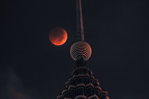A full moon sets over Petronas Twin Tower during a complete lunar eclipse in Kuala Lumpur, Malaysia, Saturday, July 28, 2018. Skywatchers around much of the world are looking forward to a complete lunar eclipse that will be the longest this century. - Sputnik International