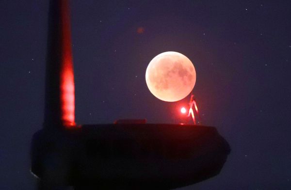 The blades from a wind turbine are silhouetted against the moon in the sky in Novogrudok, Belarus, during a total lunar eclipse on Saturday, July 28, 2018. Skywatchers around much of the world are looking forward to a complete lunar eclipse that will be the longest this century.  - Sputnik International
