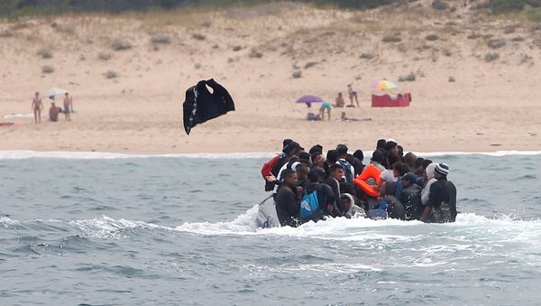 Migrants throws up a life-vest before disembarking from a dinghy at Del Canuelo beach after they crossed the Strait of Gibraltar sailing from the coast of Morocco, in Tarifa, southern Spain, July 27, 2018 Migrants throws up a life-vest before disembarking from a dinghy at Del Canuelo beach after they crossed the Strait of Gibraltar sailing from the coast of Morocco, in Tarifa, southern Spain, July 27, 2018 - Sputnik International