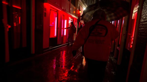 People walk through a narrow alley in the Red Light district in Amsterdam, Netherlands, Friday, Dec. 8, 2017. Every weekend, the heart of the historic port city, with its strip joints, seedy bars and scantily-clad prostitutes flaunting themselves behind plate glass windows, is overrun by foreign visitors over for stag and hen nights or to smoke marijuana in one of the city's many coffee shops. - Sputnik International