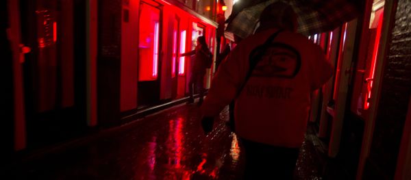 People walk through a narrow alley in the Red Light district in Amsterdam, Netherlands, Friday, Dec. 8, 2017. Every weekend, the heart of the historic port city, with its strip joints, seedy bars and scantily-clad prostitutes flaunting themselves behind plate glass windows, is overrun by foreign visitors over for stag and hen nights or to smoke marijuana in one of the city's many coffee shops. - Sputnik International