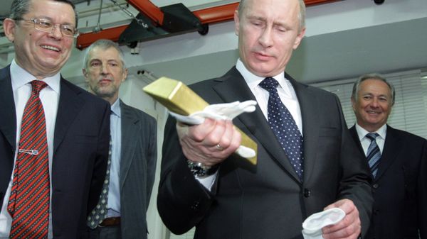 January 24, 2011. Russian Prime Minister Vladimir Putin holding a gold bar while visiting the Central Depository of the Bank of Russia. Georgy Luntovsky (left), first deputy chief of the Central Bank of Russia - Sputnik International