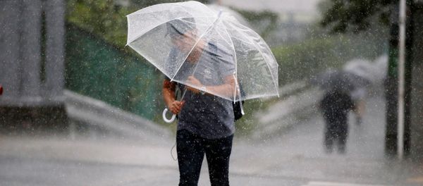 Passersby using umbrella struggles against a heavy rain and wind as Typhoon Jongdari approaches Japan's mainland in Tokyo, Japan July 28, 2018. - Sputnik International