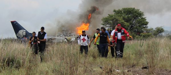 In this photo released by Red Cross Durango communications office, Red Cross workers and rescue workers carry an injured person on a stretcher, right, as airline workers, left, walk away from the site where an Aeromexico airliner crashed in a field near the airport in Durango, Mexico, Tuesday, July 31, 2018 - Sputnik International