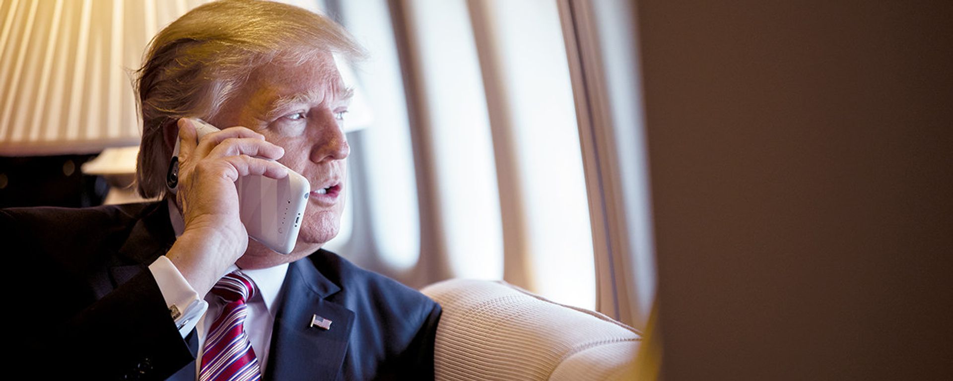 President Donald Trump talks on the phone aboard Air Force One during a flight to Philadelphia, Pennsylvania, to address a joint gathering of House and Senate Republicans, Thursday, January 26, 2017 (File photo). - Sputnik International, 1920, 04.12.2020