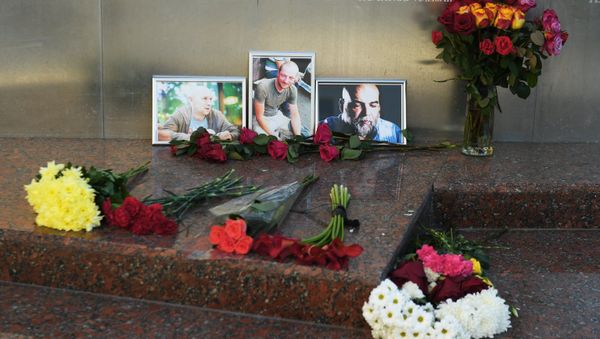 Flowers brought at the photos of three Russian journalists killed in the Central African Republic, from right: Orkhan Dzhemal, Kirill Radchenko and Alexander Rastorguyev, near the Central House of Journalists in Moscow. File photo - Sputnik International