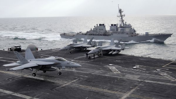 This file photo taken on Monday, Feb. 13, 2012 shows a U.S. F-18 fighter jet, left, land on the Nimitz-class aircraft carrier USS Abraham Lincoln (CVN 72) as a U.S. destroyer sells on alongside during fly exercises in the Persian Gulf This file photo taken on Monday, Feb. 13, 2012 shows a U.S. F-18 fighter jet, left, land on the Nimitz-class aircraft carrier USS Abraham Lincoln (CVN 72) as a U.S. destroyer sells on alongside during fly exercises in the Persian Gulf - Sputnik International