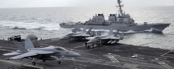 This file photo taken on Monday, Feb. 13, 2012 shows a U.S. F-18 fighter jet, left, land on the Nimitz-class aircraft carrier USS Abraham Lincoln (CVN 72) as a U.S. destroyer sells on alongside during fly exercises in the Persian Gulf This file photo taken on Monday, Feb. 13, 2012 shows a U.S. F-18 fighter jet, left, land on the Nimitz-class aircraft carrier USS Abraham Lincoln (CVN 72) as a U.S. destroyer sells on alongside during fly exercises in the Persian Gulf - Sputnik International
