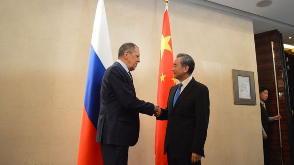 Russian Foreign Minister Sergei Lavrov Shake Hands with his Chinese counterpart Wang Yi - Sputnik International