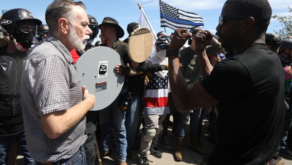 Right-wing supporters of the Patriot Prayer group (L) exchange words with a counter-demonstrator during a rally in Portland, Oregon, U.S. August 4, 2018. - Sputnik International