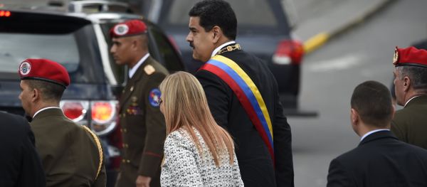 Venezuelan President Nicolas Maduro (C) and his wife Cilia Flores arrive for a ceremony to celebrate the 81st anniversary of the National Guard in Caracas on August 4, 2018 day in which Venezuela's controversial Constituent Assembly marks its first anniversary. The Constituent Assembly marks its first anniversary on August 4 as the embodiment of Maduro's entrenchment in power despite an economic crisis that has crippled the country's public services and destroyed its currency. The assembly's very creation last year was largely responsible for four months of street protests that left some 125 people dead. - Sputnik International