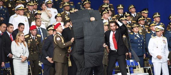 In this photo released by China's Xinhua News Agency, security personnel surround Venezuela's President Nicolas Maduro during an incident as he was giving a speech in Caracas, Venezuela, Saturday, Aug. 4, 2018 In this photo released by China's Xinhua News Agency, security personnel surround Venezuela's President Nicolas Maduro during an incident as he was giving a speech in Caracas, Venezuela, Saturday, Aug. 4, 2018 - Sputnik International