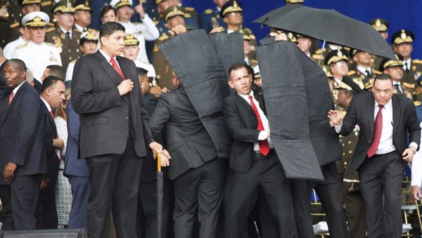 Personal de seguridad rodea al presidente de Venezuela, Nicolás Maduro, durante un incidente mientras daba un discurso en Caracas - Sputnik International