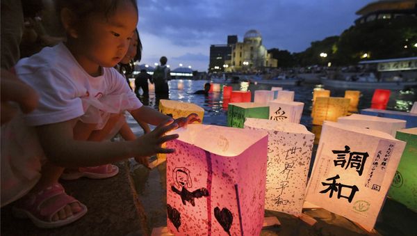A girl releases paper lanterns on the Motoyasu river facing the gutted Atomic Bomb Dome in remembrance of atomic bomb victims on the 73rd anniversary of the bombing of Hiroshima, western Japan, August 6, 2018 - Sputnik International