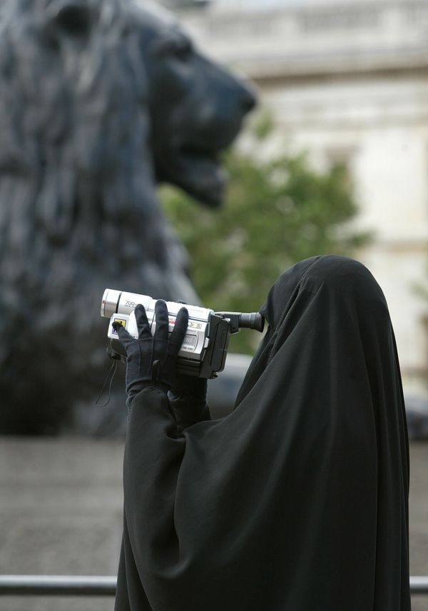 A woman in traditional Muslim gowns videofilms her family under the watchful eyes of the lions guarding the Nelson column at Trafalgar square in London, 12 August 2002.  - Sputnik International